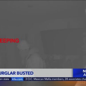Burglar caught on security camera staring at sleeping couple