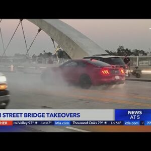 Spectators scale 6th Street bridge to watch cars drift, do burnouts