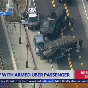 Police in standoff with Uber passenger armed with a gun