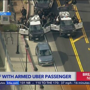 Police standoff continues with Uber passenger armed with a gun