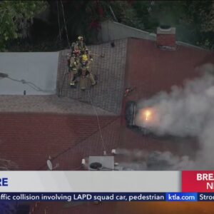 Fire erupts through roof of Reseda home