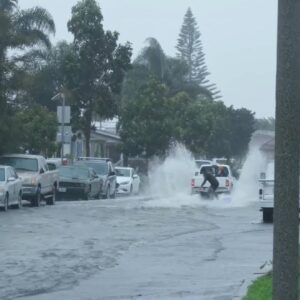 Locals surf on flooded street in Ventura, California