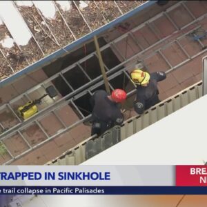 Rescue underway to save woman trapped in 25-foot sinkhole in Fontana