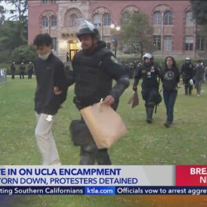 Police in riot gear detain protesters as the pro-Palestinian encampment is dismantled at UCLA