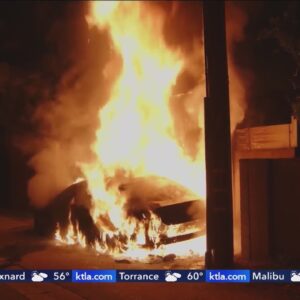 EV goes up in flames, scorches building in Granada Hills