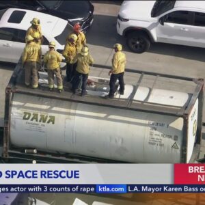 Fire crews rescue two that fell into container truck