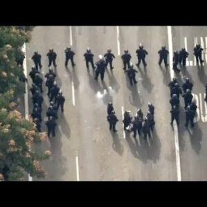 Police in riot gear march Dodgers parade route as fans get unruly