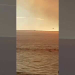 Firefighting aircraft scoop up ocean water to battle Palisades Fire